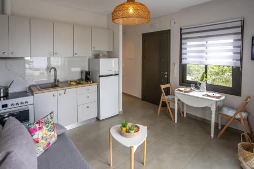 a kitchen and living room with a couch and a table at Azzure Heaven in Loutrá Elevtherón