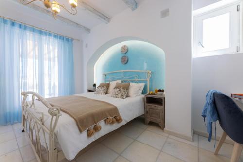 a bedroom with a bed with a blue headboard at Velonis Villa with private pool and sea view in Agia Anna Naxos