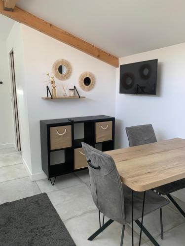 une salle à manger avec une table et des chaises en bois dans l'établissement Studio cosy proche plages, à Anglet