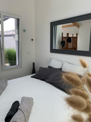 - une chambre avec un lit blanc et un grand miroir dans l'établissement Studio cosy proche plages, à Anglet