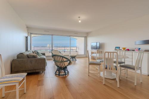un salon avec un canapé et des chaises dans l'établissement Sea-facing apartment for 4 people, à Le Touquet-Paris-Plage