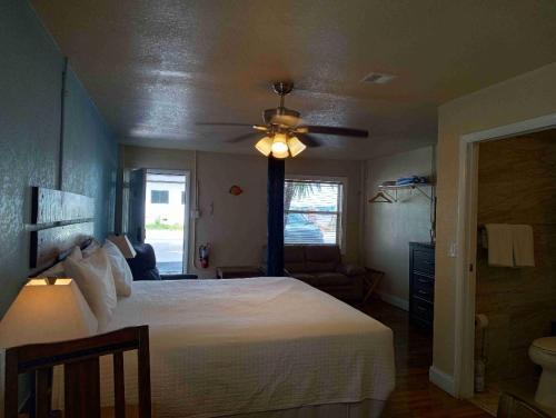 a bedroom with a white bed and a ceiling fan at Knight's Key Suites in Marathon