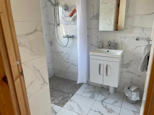 a white bathroom with a sink and a shower at River View in Quignalahy