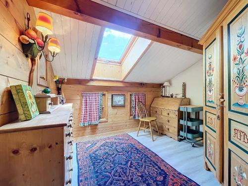 une chambre mansardée avec un tapis et une fenêtre dans l'établissement Copalme-appartement-6pers-Centre Village, aux Gets