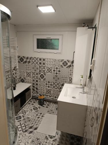 a bathroom with a sink and a shower at Petite maison dans les bois in Villefranque