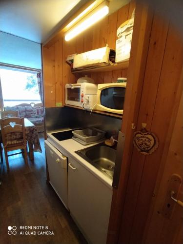 une petite cuisine avec un évier et un micro-ondes dans l'établissement Arcs 1800 Belles Challes Studio 5 personnes, à Arc 1800