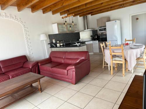 a living room with a red couch and a table at Gite au calme à 15 min d'Albi, 7 personnes in Taïx