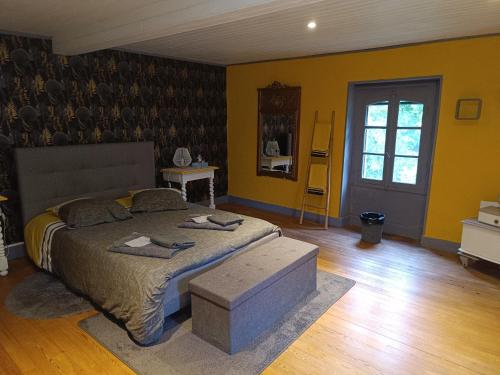 a bedroom with a large bed and yellow walls at Petite maison dans les bois in Villefranque