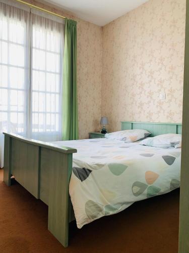 une chambre avec un grand lit dans une pièce dans l'établissement Les Cormiers, à Chailles