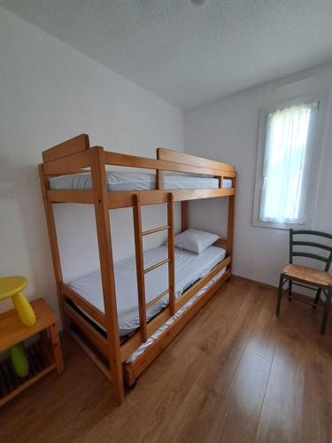 deux lits superposés dans une chambre avec fenêtre dans l'établissement Chalet de vacances aux abords du lac d'Hourtin, à Hourtin