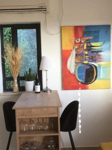 a room with a table and a painting on the wall at Kineret View in Neot Golan