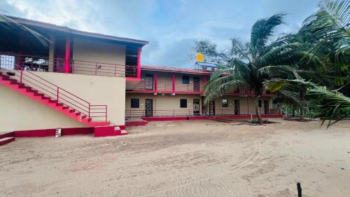 a building with a palm tree in front of it at Nakshatra Beach Stay in Gokarn