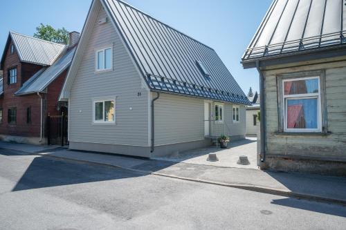 a house with a metal roof next to a building at Pärnu Pearl Residences in Pärnu