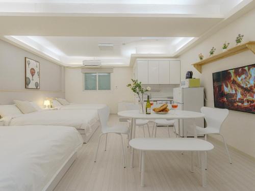 una habitación con dos camas y una mesa y sillas en DK House, en Seúl