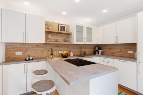a white kitchen with white cabinets and a sink at Moderner Schwarzwaldtraum in Oberharmersbach