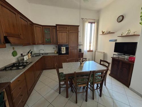 a kitchen with wooden cabinets and a table and chairs at Appartamento VialeMarconi139, San Miniato in San Miniato Basso