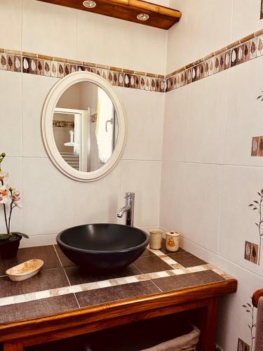 une salle de bain avec un lavabo noir et un miroir dans l'établissement Spacieuse Maison de Vacance Villa Les Lavandins, à Puisserguier