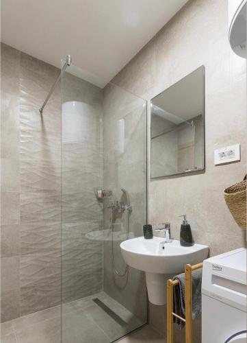 a bathroom with a sink and a glass shower at Anja Apartment in Bečići