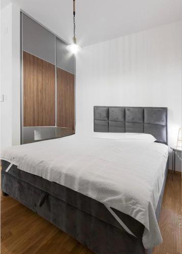 a bedroom with a large bed in a white room at Anja Apartment in Bečići