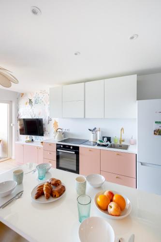 une cuisine blanche avec des assiettes de nourriture sur un comptoir dans l'établissement Escapade au Brusc - Les pieds dans l'eau, à Six-Fours-les-Plages