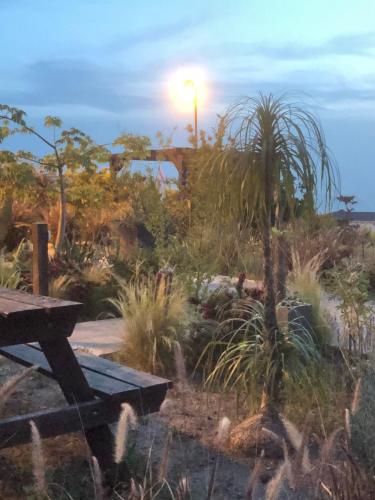 a garden with a picnic table and a palm tree at Kineret View in Neot Golan