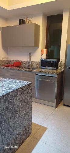 a kitchen with a counter top and a microwave at Precioso departamento en Acapulco Diamante in Acapulco