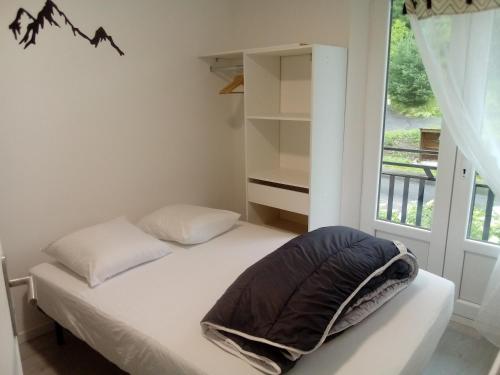 a small bedroom with a bed and a window at appt tout confort a laveissiere 103 in Laveissière