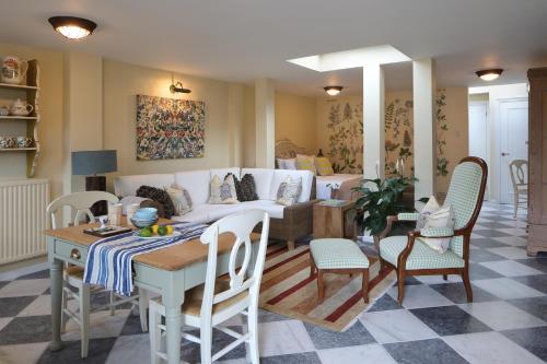 a living room with a couch and a table and chairs at Steeple View - Romantic Wye Valley Country House Studio Apartment - Dog Friendly in Newland