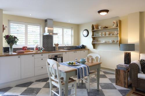 a kitchen with a table and chairs in a room at Steeple View - Romantic Wye Valley Country House Studio Apartment - Dog Friendly in Newland