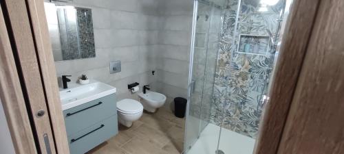 a bathroom with a toilet and a glass shower at B&b La Campanella in Palagianello