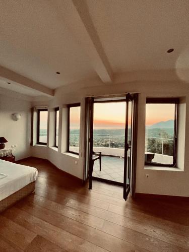 a bedroom with a bed and windows with a view at Zografos Studios Zacharo Zakharo in Zakharo