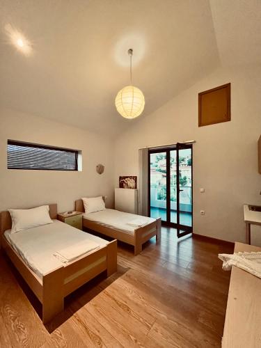 a bedroom with two beds and a pendant light at Zografos Studios Zacharo Zakharo in Zakharo