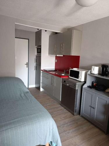 - une petite cuisine avec un lit dans une chambre dans l'établissement Location studio Cap d'Agde, au Cap d'Agde