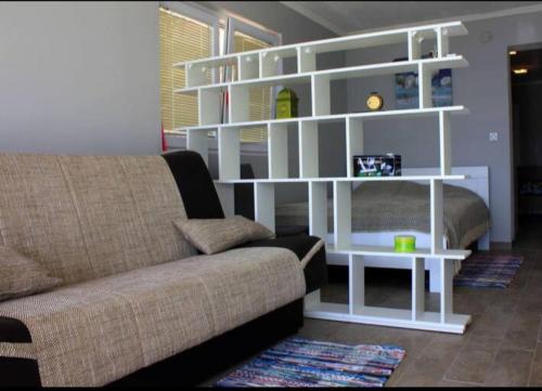 a living room with a couch and white shelves at Odessa Mama in Bijela