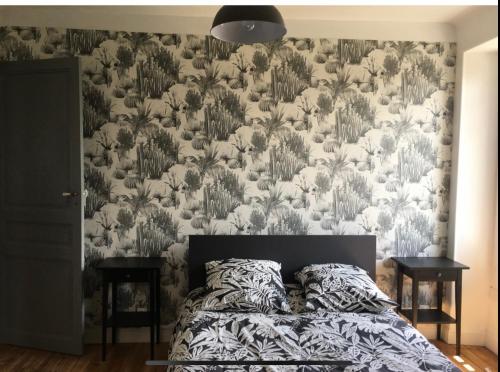 une chambre avec un lit avec un papier peint fleuri dans l'établissement Jeanne Marie, à Bayonne