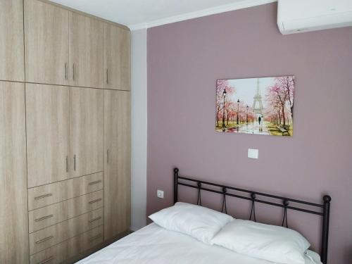 a bedroom with a bed and a painting on the wall at Chris&Chris Luxury apartment in Mesolongion