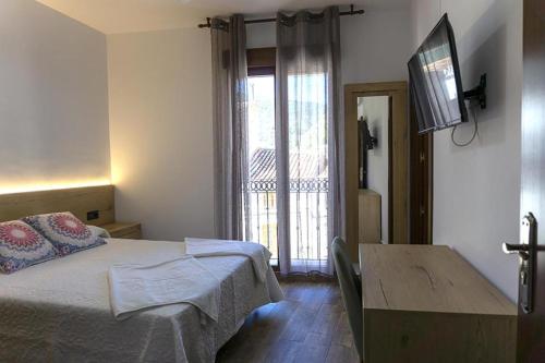 a bedroom with a bed and a table and a window at Alojamientos Rurales Entre Rocas in Ayna
