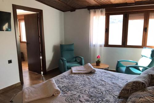 a bedroom with a bed and chairs in a room at Alojamientos Rurales Entre Rocas in Ayna