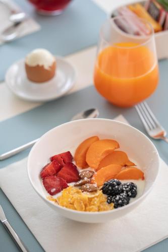 a bowl of cereal and fruit with a glass of orange juice at Santa Maria Vecchia Relais in Vico Equense