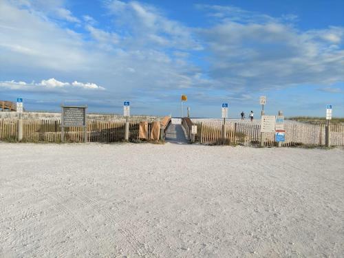 a beach with a fence and people on the beach at Sunset Harbor The Palms in Navarre