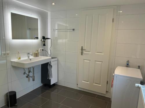 DierdorfにあるNeue Ferienwohnung Dierdorfの洗面台と鏡のある白いバスルーム