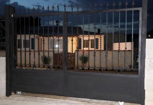 a black gate with a building reflected in the window at Casa Valle del Hontanar in Cardenete