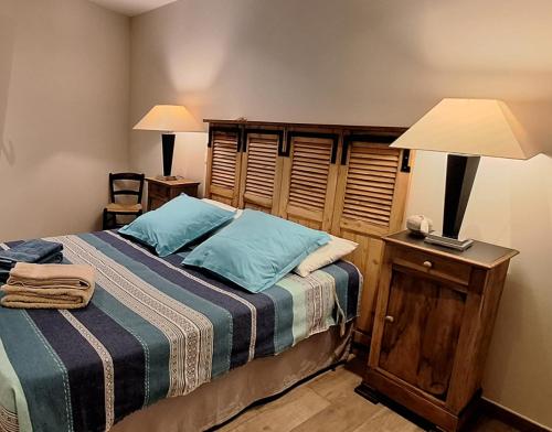 - une chambre avec un lit doté d'oreillers bleus et d'une lampe dans l'établissement Hameau Provençal - T2 NEUF très calme tout à pied prestation +++, à Six-Fours-les-Plages