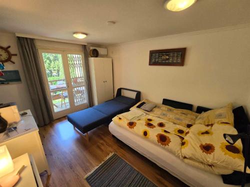 a bedroom with a bed and a couch in it at Rózsakő Apartman in Balatonalmádi