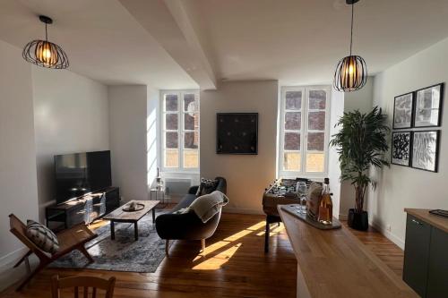 un salon avec un canapé et une table dans l'établissement Appartement Les Reflets du Tournesol, à Mortagne-au-Perche