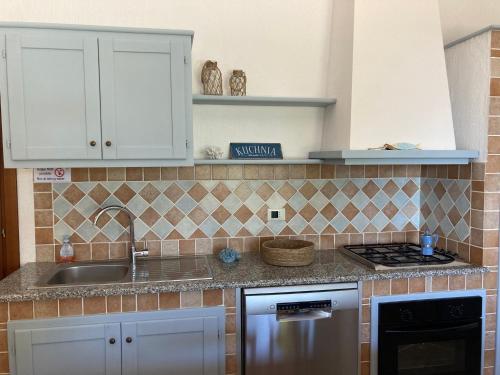 a kitchen with a sink and a stove at Abba Sixty - View, Pool & Parking - 200mt Sea in Tertenìa