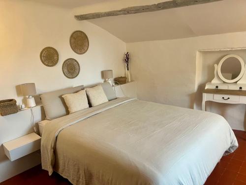 une chambre avec un grand lit blanc et un miroir dans l'établissement Charming & medieval village house completely renovated with great exterior and views, à Mallemort