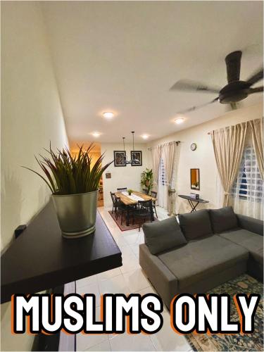 a living room with a couch and a ceiling fan at Inang Homestay in Teluk Intan