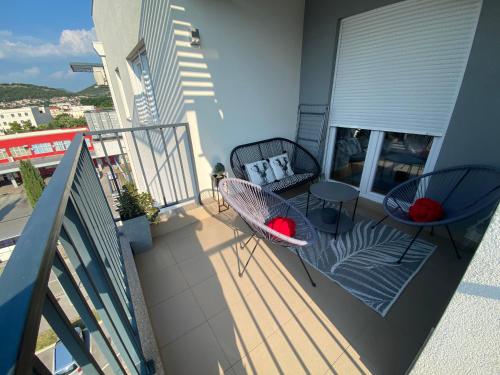 ein Balkon mit zwei Stühlen und einem Tisch auf einem Gebäude in der Unterkunft AFRIKA in Trebinje