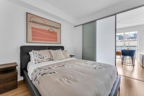 a bedroom with a bed and a large window at Estate 1 Bedroom Condo Front Street West in Toronto